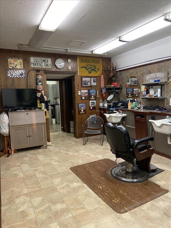 Inside the shop: a classic black barber chair beside the sinks, with sports memorabilia on the walls