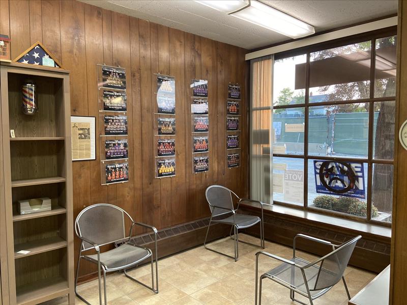 The front waiting area, with team photos on the paneled wall and a big window onto Main Street